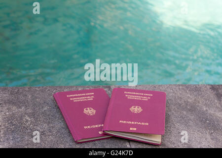Due passaporti tedeschi di fronte all'acqua turchese. Sensazione di vacanza. Foto Stock