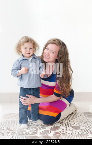 Giovane bella madre che abbraccia il suo bambino Foto Stock