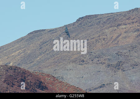 F-15C Eagle jet fighter immersioni in un canyon del deserto, sentieri di vapore lo streaming dal Wingtips. Foto Stock