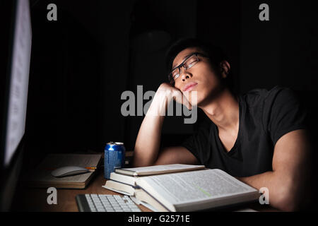 Stanco esaurito asian giovane uomo studiare e dormire nella parte anteriore del computer nelle ore notturne Foto Stock