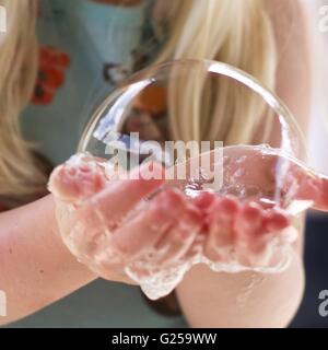 Close-up di una ragazza con una bolla di sapone Foto Stock