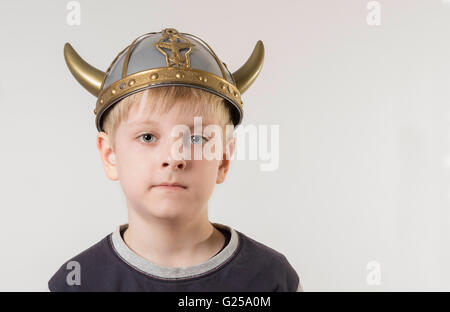 Ritratto di un ragazzo che indossa un giocattolo di plastica Viking casco Foto Stock