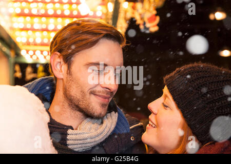 Giovane sul mercato di natale con cotone candy e fiocchi di neve Foto Stock