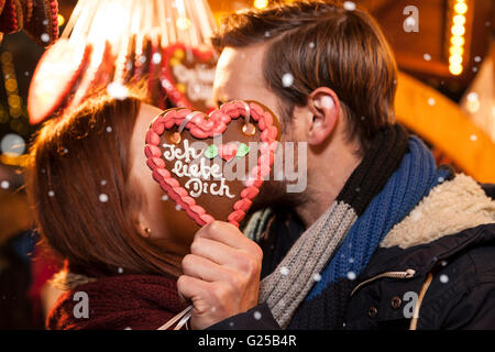 Giovane kissing sul mercato di Natale ("ti amo" in tedesco sul pan di zenzero) Foto Stock