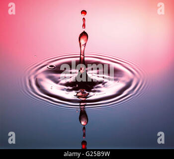 Water drop fotografia, una o due gocce di acqua è scesa da altezza in acqua e catturato in quanto colpiscono l'acqua o si scontrano w Foto Stock