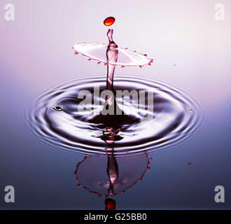 Water drop fotografia, una o due gocce di acqua è scesa da altezza in acqua e catturato in quanto colpiscono l'acqua o si scontrano w Foto Stock