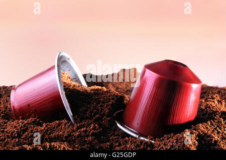 Capsule per macchina da caffè espresso sul mucchio di caffè macinato e marrone sfondo isolato Foto Stock