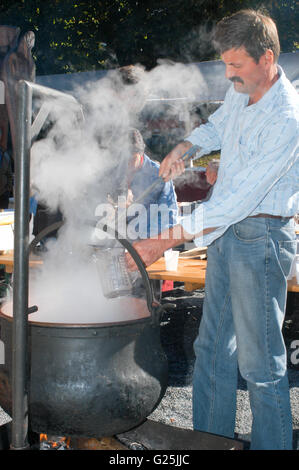 Engelberg, Svizzera - 29 Settembre 2005: l'uomo la preparazione di una bevanda tradizionale con caffè e liquore al villaggio di Engelberg Foto Stock