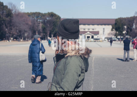 Una giovane donna è camminare nel Parco di Ueno a Tokyo Foto Stock