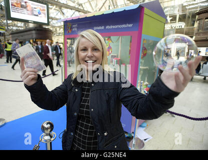 Solo uso editoriale Yvonne Stevenson da Glasgow vince un premio da un gigante in stile arcade premio chiamato riposiziona l'Ã"DreamcatcherÃ•, che dà al pubblico la possibilità di vincere una vacanza, un auto e premi in denaro per il lancio di B - un nuovo digital banking brand di Clydesdale e Yorkshire Bank, presso la Stazione Centrale di Glasgow. Foto Stock