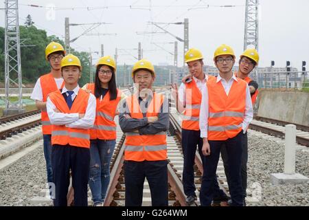 Nanchang, cinese della provincia di Jiangxi. Xxiv Maggio, 2016. Diplomati di scuola del trasporto ferroviario posano per una foto di graduazione con il loro insegnante Jianjun Hu (C) in Oriente Cina Jiaotong University di Nanchang, a est della capitale cinese della provincia di Jiangxi, 24 maggio 2016. © Hu Chenhuan/Xinhua/Alamy Live News Foto Stock