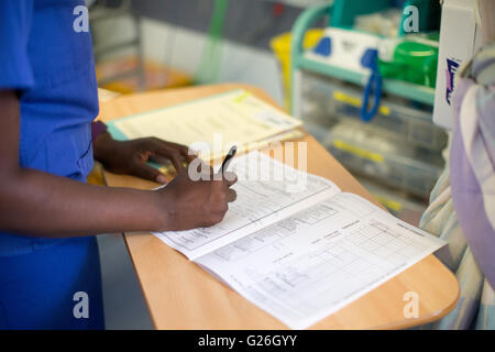 Un infermiere compila le note sul paziente in un ospedale Foto Stock