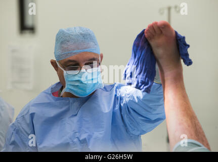 Un chirurgo si prepara un paziente per la chirurgia prima di effettuare una riduzione aperta e la fissazione interna di una caviglia sinistra Foto Stock