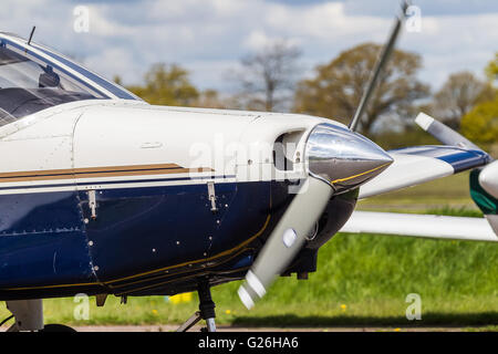 Una tenuta di close-up del naso e propulsore di un Piper PA-28, con una leggera sfocatura sull'elica Elstree Airfield, Herts UK Foto Stock