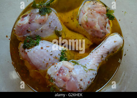 Materie cosce di pollo in marinata in vetreria Foto Stock