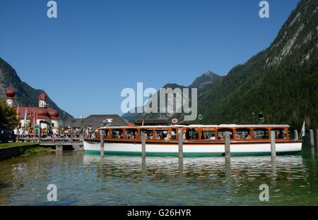 Schonau am Konigssee, Germania - 30 agosto 2015: Barca e persone non identificate al molo presso San Bartholoma chiesa al vicino lago Sc Foto Stock