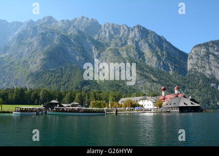 Schonau am Konigssee, Germania - 30 agosto 2015: montagne, San Bartholoma chiesa ed altri edifici e navi a lago Koenigssee Foto Stock