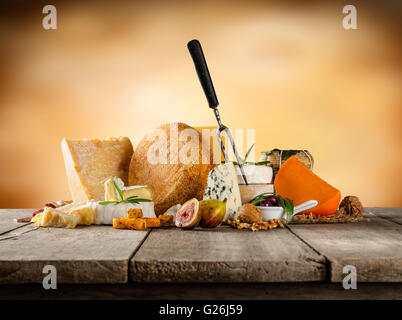 Vari tipi di formaggio collocato sul tavolo di legno, copyspace di testo con sfondo astratto Foto Stock