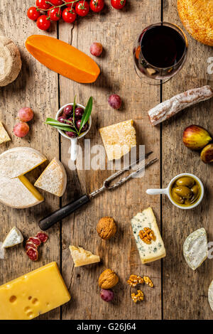 Vari tipi di formaggio tradizionale e delicatezza adatto per vino, poste su legno, girato da alto angolo di visione. Foto Stock