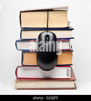 Pila di libri con copertina rigida e mouse nero Foto Stock