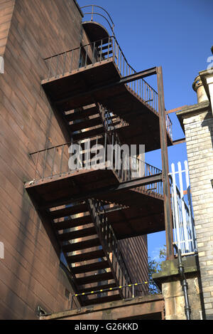 Ferro vecchio fire escape su pietra arenaria rossa edificio dal al di sotto di Glasgow, Scotland, Regno Unito. Foto Stock