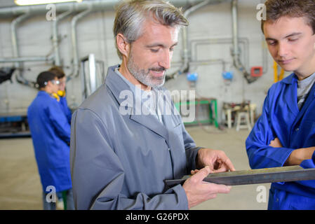 Briefing boss tirocinante in fabbrica Foto Stock