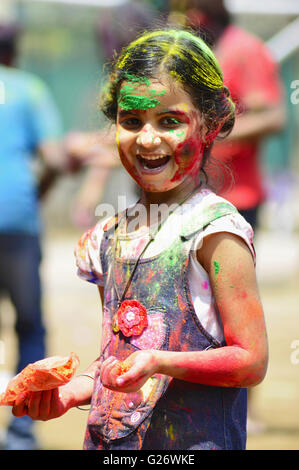 Colorato la faccia di una ragazza che gioca holi (festival di colori), Pune, Maharashtra, India Foto Stock