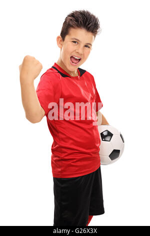 Colpo verticale di una gioiosa junior giocatore di calcio con il pugno serrato isolati su sfondo bianco Foto Stock