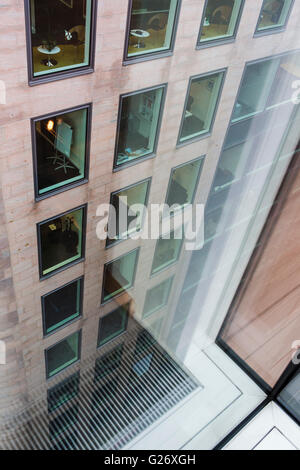 Guardando al di fuori di un ufficio a Londra il blocco finestra con riflessioni sul vetro. Foto Stock