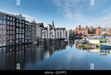 Damrak è un grande bacino del canale e la strada nei pressi di Amsterdam Centraal Station Foto Stock