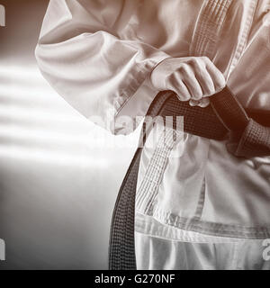 Immagine composita del fighter di serraggio della cinghia di karate Foto Stock