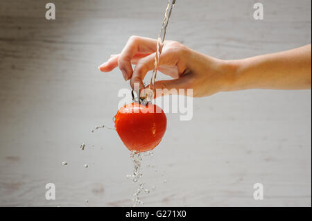 La donna lava un pomodoro Foto Stock