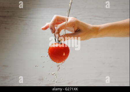 La donna lava un pomodoro Foto Stock