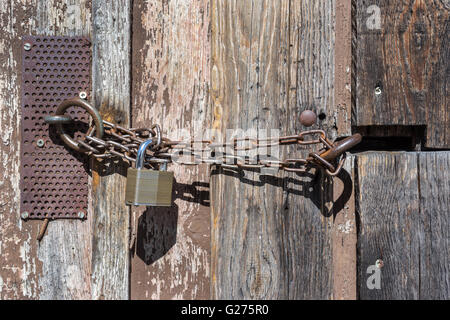 La catena con la serratura di una porta del granaio Foto Stock