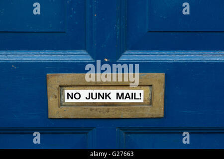 'No Junk Mail' sticker su ottone letterbox su blu dipinta porta anteriore Foto Stock