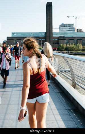 LONDON, Regno Unito - 22 agosto 2015: giovane donna e altre persone che camminano su Millennium bridge una giornata di sole. Foto Stock