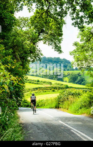 Ciclista su strada sul lato ovest del Peckforton Hills cheshire england Foto Stock