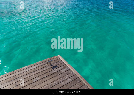 Jetty su una spiaggia tropicale. Bordo dell'acqua, pontile e la laguna blu Foto Stock