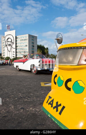 Un taxi coco, americano anni cinquanta taxi auto medio e l'immagine di Camilo Cienfuegos sulla costruzione di sfondo sulla Piazza della Rivoluzione. Foto Stock