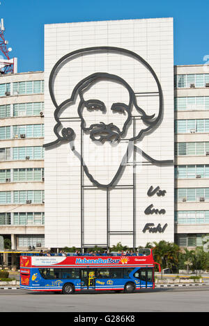 Un turista Havana La Habana hop on hop off bus sulla Piazza della Rivoluzione con l'immagine di Camilo Cienfuegos in background. Foto Stock