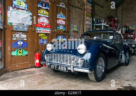 1958 Triumph TR3. Classico auto in un garage a Bicester Heritage Centre. Oxfordshire, Inghilterra Foto Stock