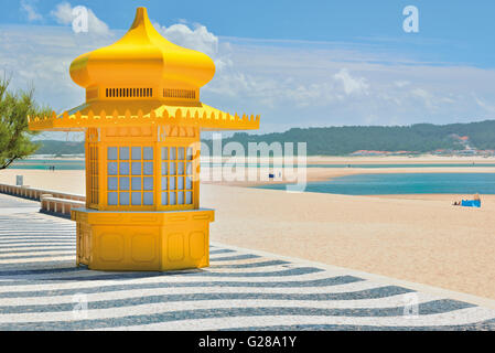 Portogallo: chiosco giallo e decorate portoghese marciapiede in ciottoli con sabbia e la laguna Lagoa de Obidos in Foz do Arelho Foto Stock