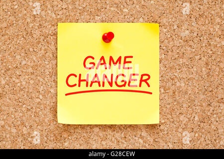 Game Changer scritto sul bigliettino giallo con contrassegno rosso imperniata sulla bacheca di sughero. Foto Stock