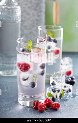 Acqua frizzante con berry e ghiaccio alle erbe Foto Stock