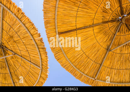 Dettaglio di bambù due ombrelloni contro un cielo blu Foto Stock