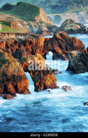 Bagliore di sera lungo la California's robusto Big Sur costa con la storica Rocky Creek ponte sull'autostrada. Foto Stock