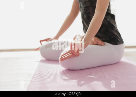 Attraente giovane giapponese la pratica dello yoga in una stanza ariosa Foto Stock