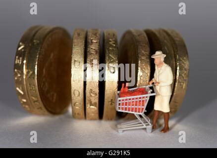 Statuetta in miniatura donna anziana spingendo un supermercato carrello della spesa tra british una libbra di monete. Foto Stock