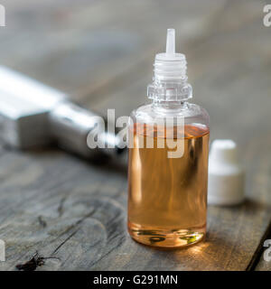 Sigaretta elettronica aroma liquido su sfondo di legno, close up Foto Stock