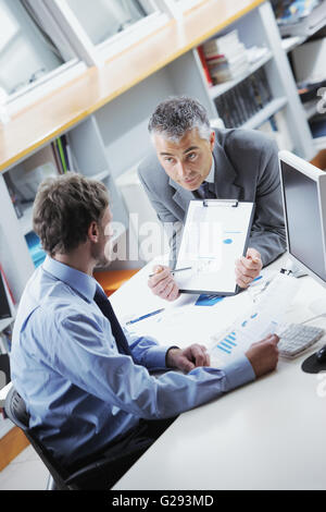 Colleghi di lavoro per discutere insieme in un ufficio Foto Stock
